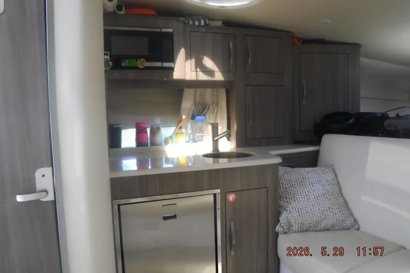 Slide: The Image of Interior of 2020 Regal 33 XO yacht featuring kitchenette and seating area. - 39