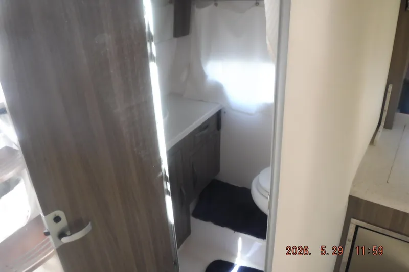 Slide: The Image of Interior bathroom of 2020 Regal 33 XO boat with wooden door and modern fixtures. - 41
