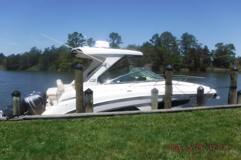 Slide: The Image of 2020 Regal 33 XO boat docked by a scenic lakeside. - 46