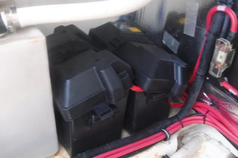 Slide: The Image of Battery compartment of 2020 Regal 33 XO boat with red cables and black casings. - 51