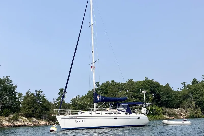 The Image of 2004 Catalina 350 sailboat anchored in a serene bay. - 1