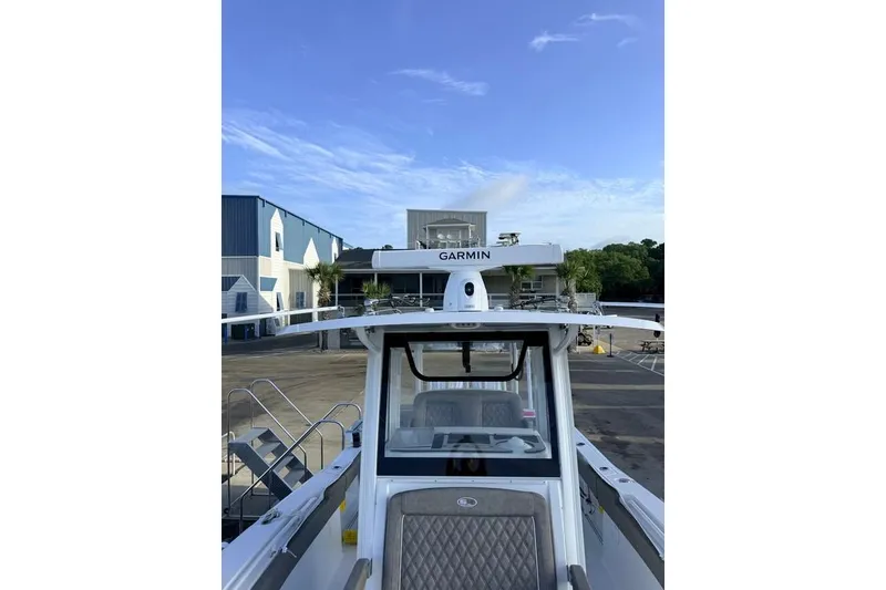 Slide: The Image of 2026 Sea Hunt Gamefish 30 Coffin Box boat with Garmin equipment, docked under clear sky. - 15