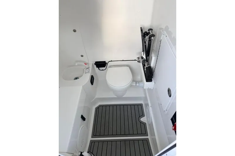 Slide: The Image of Interior of 2026 Sea Hunt Gamefish 30 Coffin Box boat, featuring compact bathroom amenities. - 16