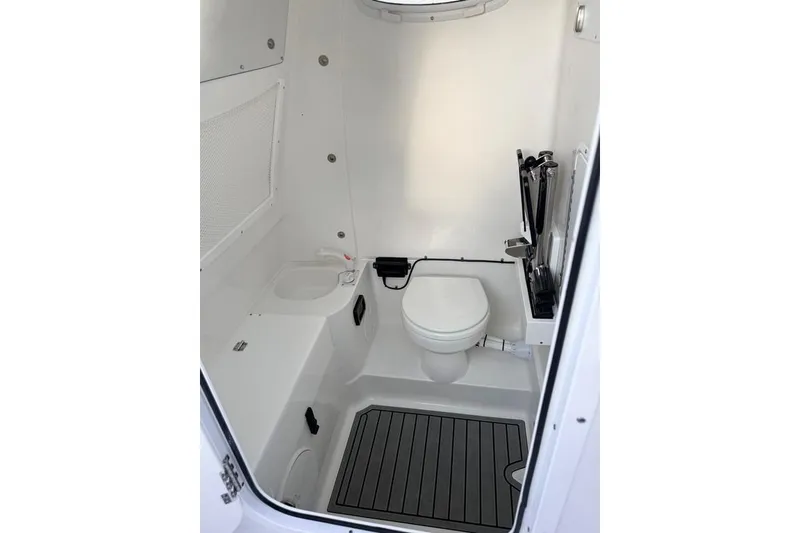 Slide: The Image of Interior of 2026 Sea Hunt Gamefish 30 Coffin Box boat bathroom, featuring toilet and storage. - 17