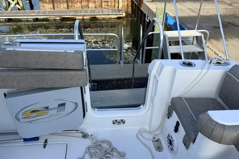Slide: The Image of 2026 Sea Hunt Gamefish 30 Coffin Box boat interior with seating and dock view. - 26