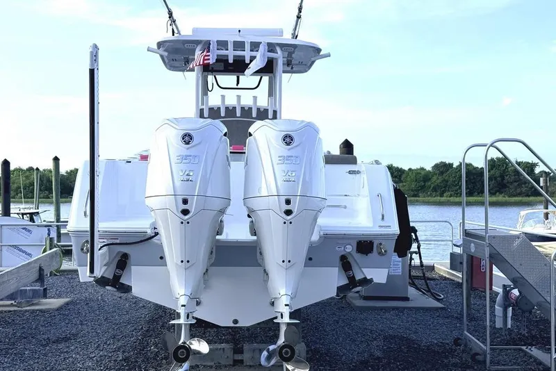 Slide: The Image of 2026 Sea Hunt Gamefish 30 Coffin Box with twin 350 V8 engines docked by the water. - 3
