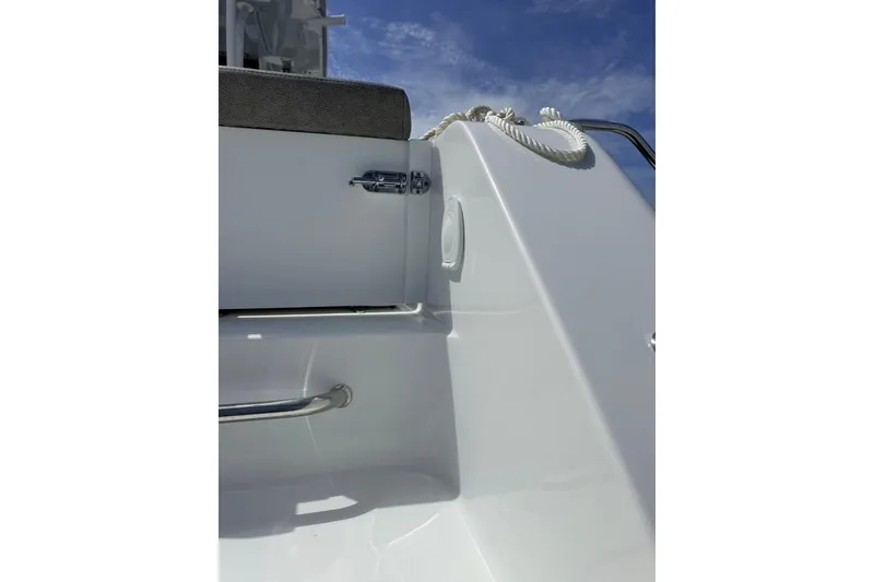 Slide: The Image of 2026 Sea Hunt Gamefish 30 Coffin Box boat detail with latch and rope against blue sky. - 30