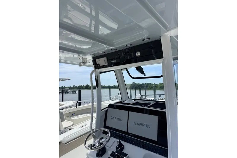 Slide: The Image of 2026 Sea Hunt Gamefish 30 Coffin Box helm with dual Garmin displays, docked by the water. - 8