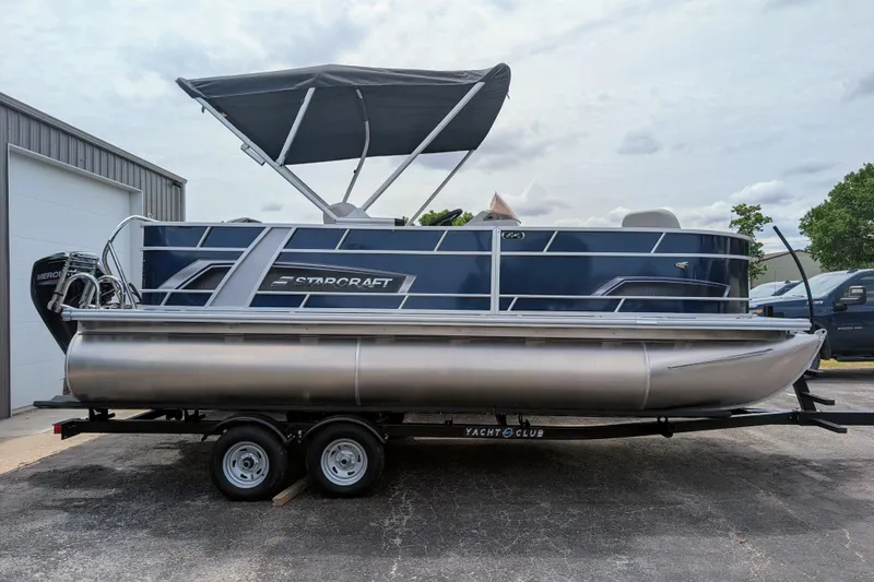 The Image of 2026 Starcraft EX 20 F pontoon boat on trailer, featuring sleek design and canopy. - 1