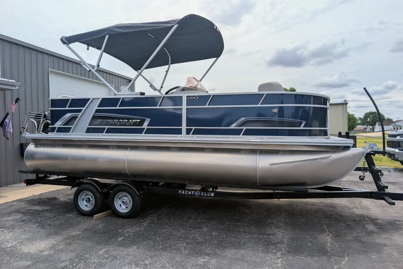 Slide: The Image of 2026 Starcraft EX 20 F pontoon boat on trailer, parked outdoors. - 13