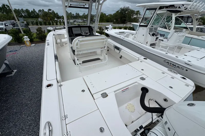 Slide: The Image of 2023 Robalo 266 Cayman boat interior with seating and console, displayed outdoors. - 10
