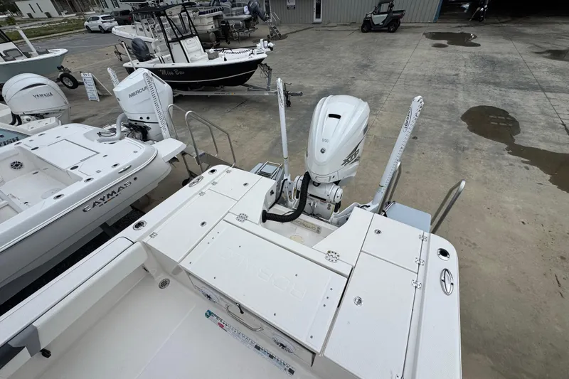 Slide: The Image of 2023 Robalo 266 Cayman boat with outboard motor in a marina setting. - 11