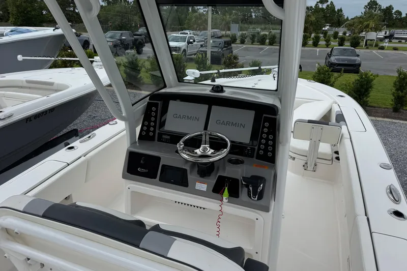 Slide: The Image of 2023 Robalo 266 Cayman boat cockpit with Garmin navigation system and steering wheel. - 12