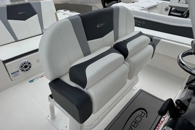 Slide: The Image of 2023 Robalo 266 Cayman boat interior with cushioned seating and steering wheel. - 15