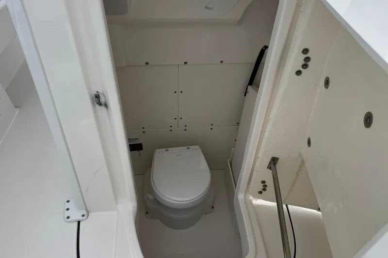 Slide: The Image of 2023 Robalo 266 Cayman boat interior with compact marine toilet. - 23