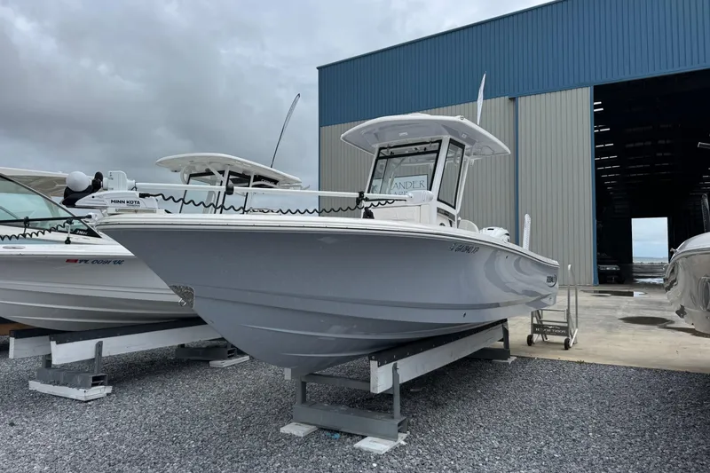 Slide: The Image of 2023 Robalo 266 Cayman boat displayed outside a large storage facility. - 7
