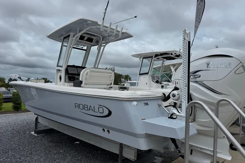 Slide: The Image of 2023 Robalo 266 Cayman boat with Yamaha engine, displayed outdoors under cloudy skies. - 9