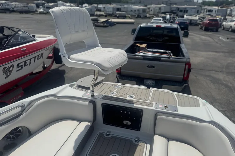 Slide: The Image of 2022 Crownline Eclipse E205 XS Fish boat with elevated seat, parked near vehicles. - 10