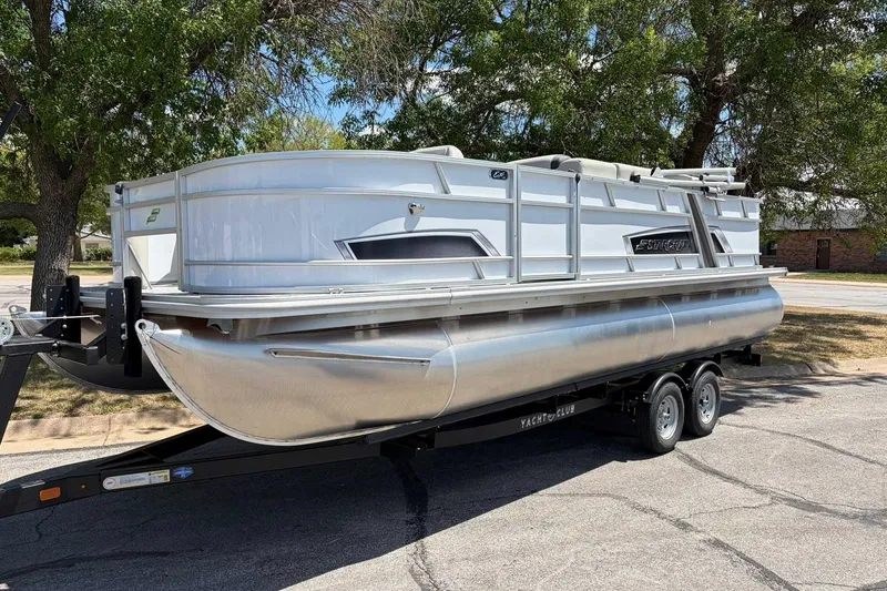 Slide: The Image of 2026 Starcraft EX 22 FD4 pontoon boat on trailer, parked outdoors. - 6