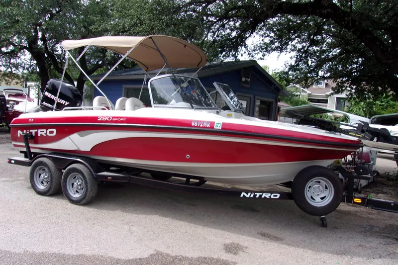 The Image of 2013 Nitro 290 Sport boat with Mercury engine on trailer, parked outdoors. - 1