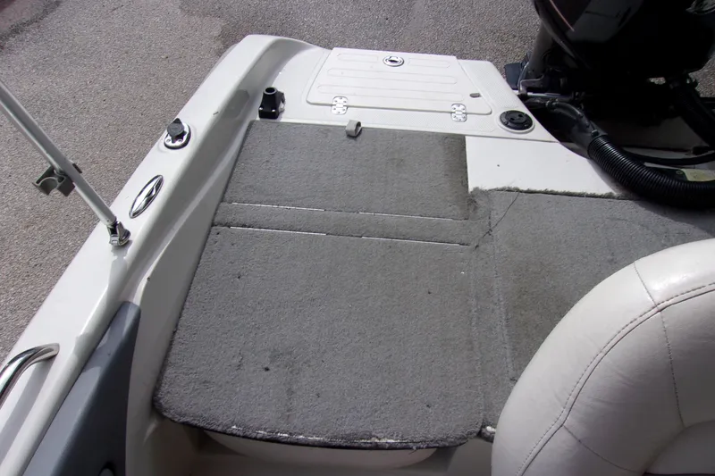 Slide: The Image of 2013 Nitro 290 Sport boat deck with gray carpet and seating area. - 17