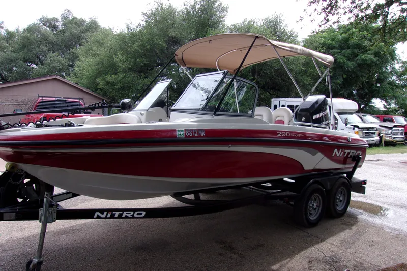 Slide: The Image of 2013 Nitro 290 Sport boat on trailer, red and white, parked outdoors. - 4