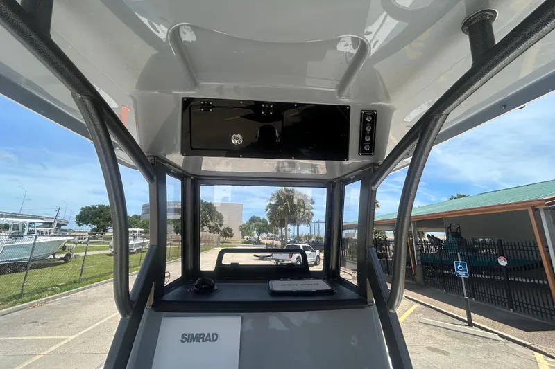 Slide: The Image of 2026 Sea Pro 250 Bay boat interior with Simrad electronics, docked under clear skies. - 17