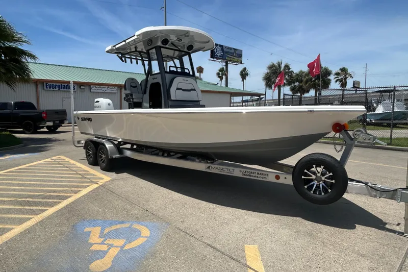 Slide: The Image of 2026 Sea Pro 250 Bay boat on trailer at dealership, sunny day. - 2