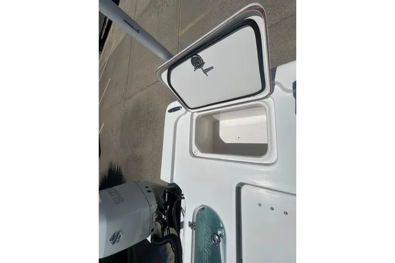 Slide: The Image of 2026 Sea Pro 250 Bay boat with open storage compartment and Suzuki engine. - 25