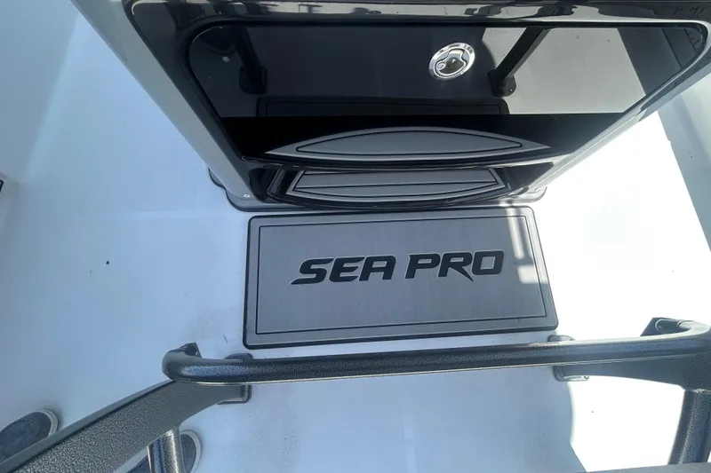 Slide: The Image of 2026 Sea Pro 250 Bay boat interior with branded flooring and storage compartment. - 27