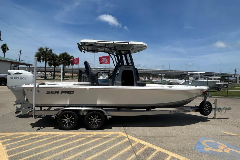 Slide: The Image of 2026 Sea Pro 250 Bay boat on trailer, parked outdoors under clear sky. - 4