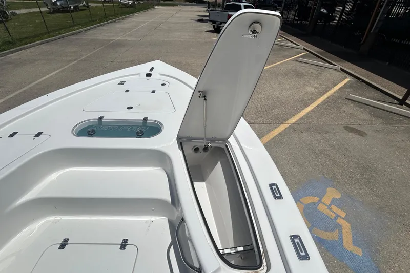 Slide: The Image of 2026 Sea Pro 250 Bay boat with open storage compartment in a parking lot. - 8
