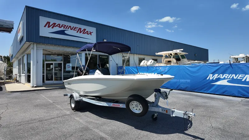 Slide: The Image of A 2027 Boston Whaler 160 Super Sport on a trailer outside a marine dealership. - 10
