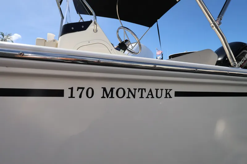 Slide: The Image of Close-up of a Boston Whaler 170 Montauk side with helm and sunshade visible. - 15