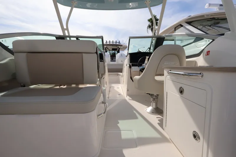 Slide: The Image of Interior view of a Boston Whaler 240 Vantage with beige seating and helm console. - 11