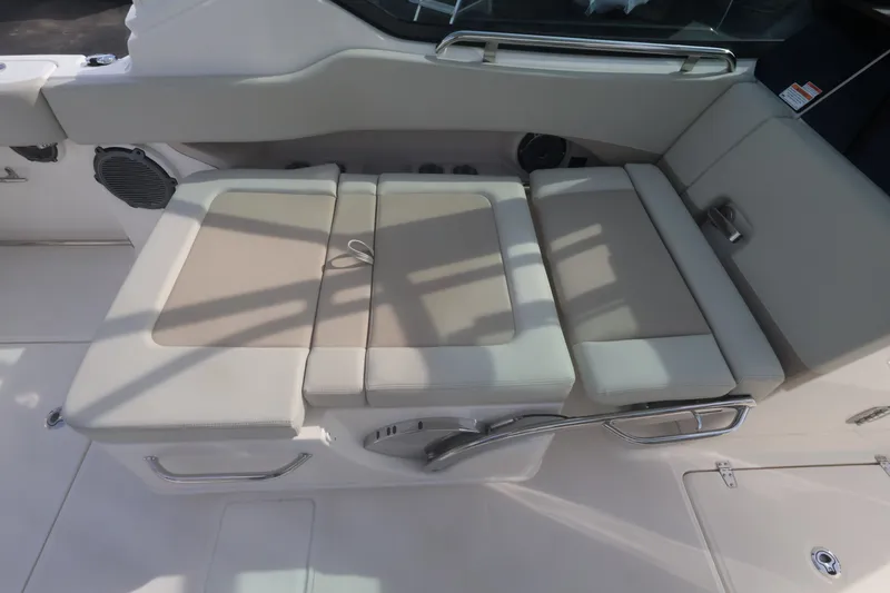 Slide: The Image of The 2027 Boston Whaler 240 Vantage features a cushioned bench seat with beige padding and stainless steel handles. - 20