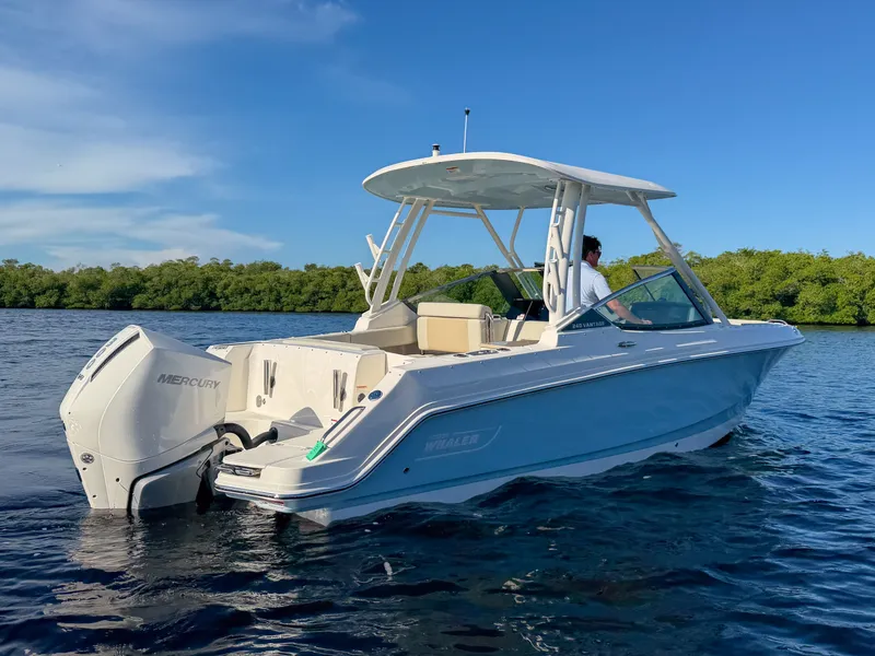 Slide: The Image of Boston Whaler 240 Vantage 2027 on calm water with outboard motor and protective hardtop. - 6