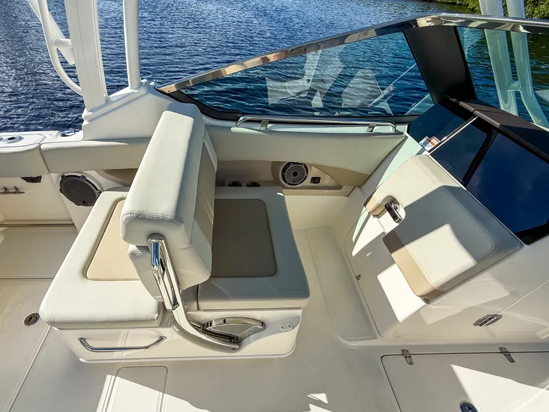 Slide: The Image of The image shows the helm of a 2027 Boston Whaler 240 Vantage with beige seating. - 10