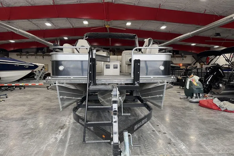 Slide: The Image of 2016 Manitou 24 Aurora LE Angler pontoon boat in a spacious indoor showroom. - 1