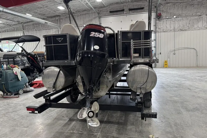 Slide: The Image of 2016 Manitou 24 Aurora LE Angler pontoon boat in a spacious indoor storage facility. - 5