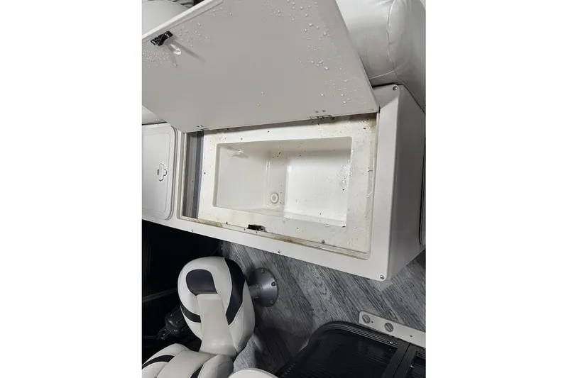 Slide: The Image of Open storage compartment on 2016 Manitou 24 Aurora LE Angler boat, with seating visible. - 8