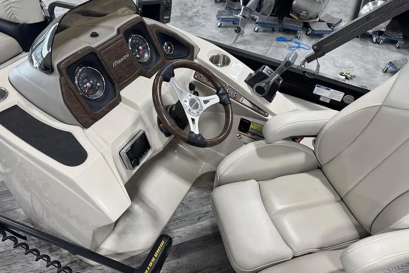 Slide: The Image of 2016 Manitou 24 Aurora LE Angler boat dashboard with steering wheel and gauges. - 9
