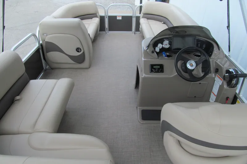 Slide: The Image of 2023 Sun Tracker Party Barge 18 DLX interior with beige seating and modern helm controls. - 4