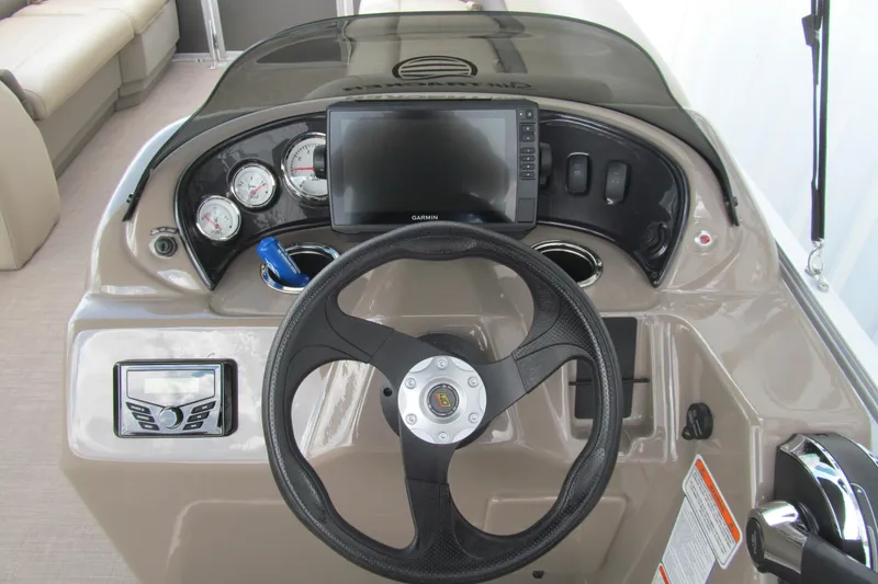 Slide: The Image of 2023 Sun Tracker Party Barge 18 DLX dashboard with steering wheel and navigation display. - 5