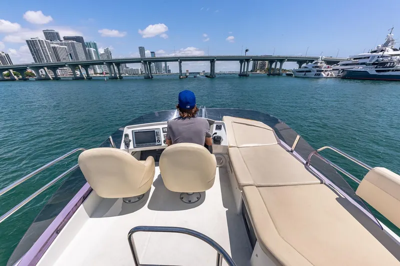 Slide: The Image of Person steering 2011 Beneteau Gran Turismo 49 Fly yacht in sunny city harbor. - 18