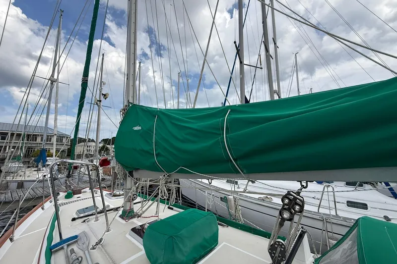 Slide: The Image of Sailboat deck view of 1989 Cabo Rico 34 with green sail cover. - 13