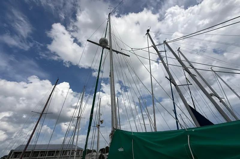 Slide: The Image of Sailboat masts against a cloudy sky, featuring a 1989 Cabo Rico 34. - 14