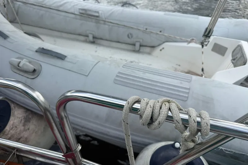 Slide: The Image of Rope tied on a Cabo Rico 34 sailboat railing, with inflatable dinghy in background. - 19