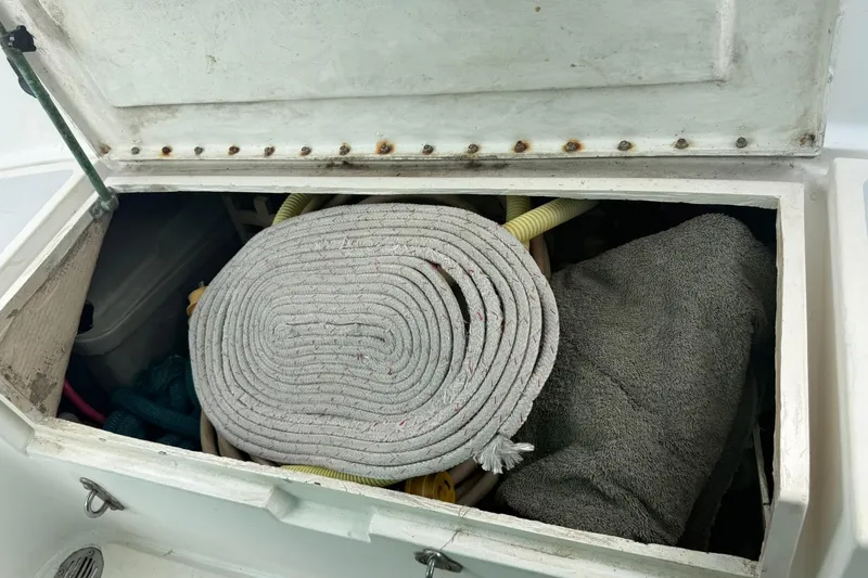 Slide: The Image of Open storage compartment on 1989 Cabo Rico 34 sailboat with coiled rope and supplies. - 23