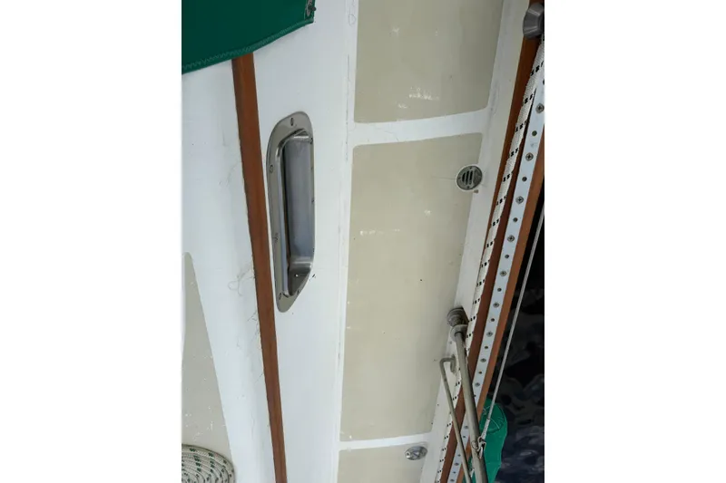 Slide: The Image of Close-up of 1989 Cabo Rico 34 sailboat deck with metal fittings and wood trim. - 24